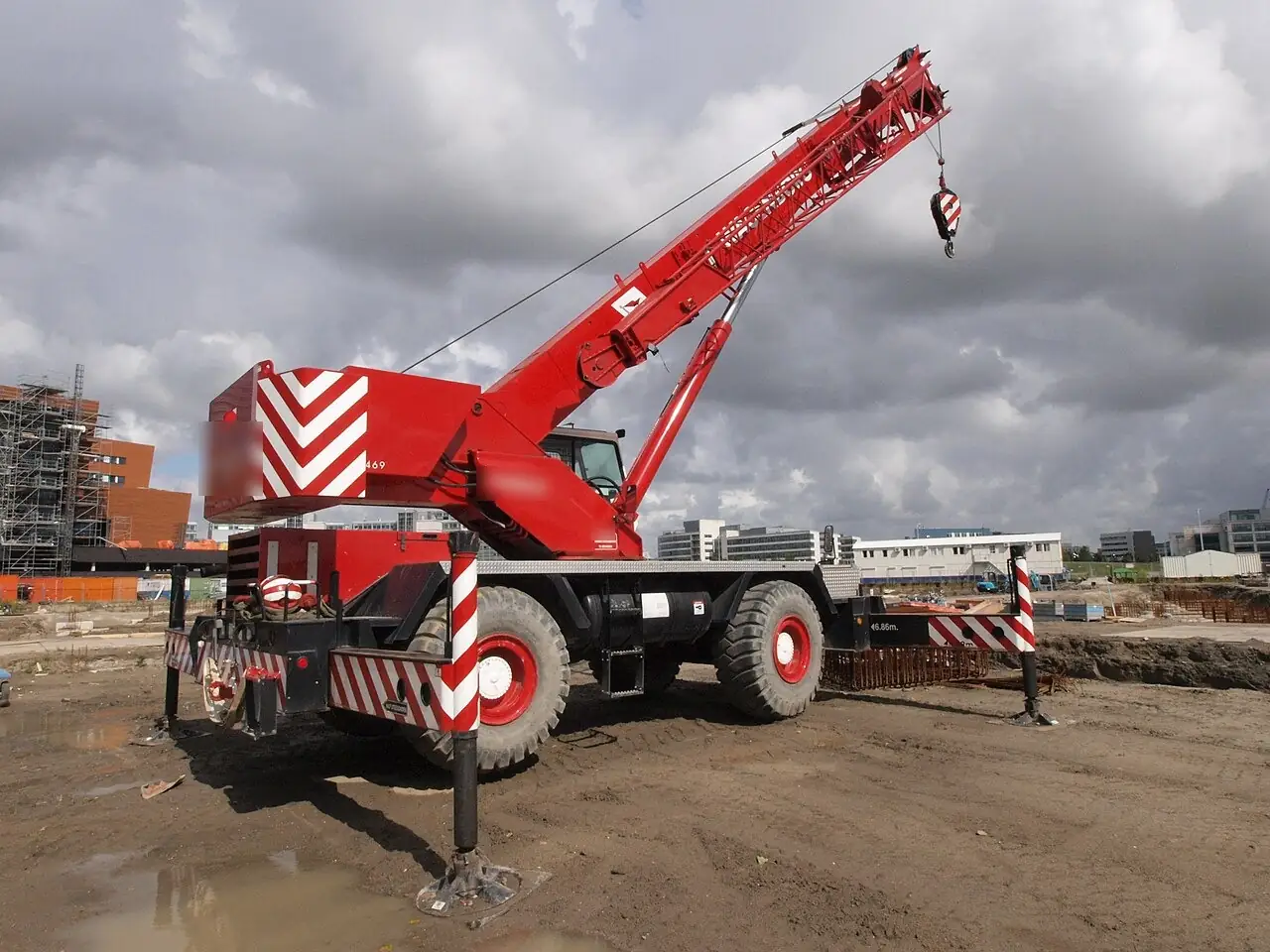 Rough-terrain crane with outriggers set on a job site